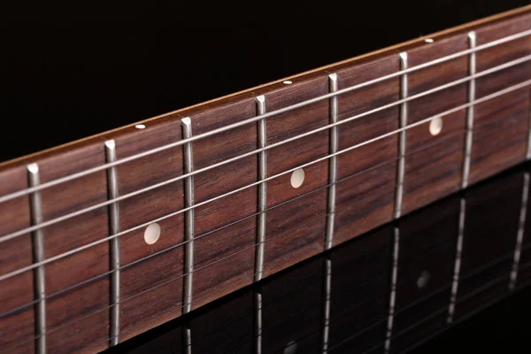 Detalle del diapasón de una guitarra, sobre fondo oscuro con r — Foto de Stock