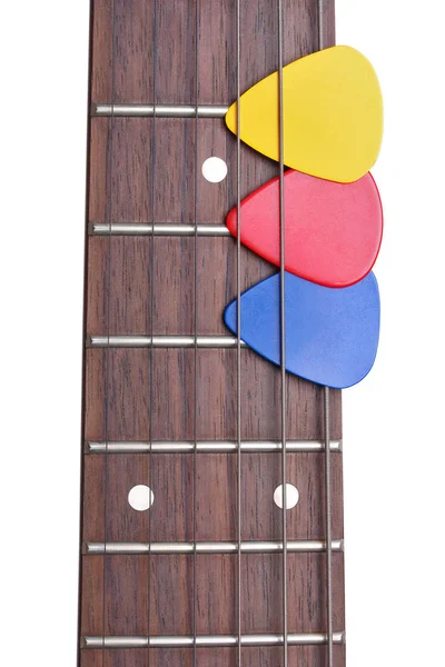Tres mediadores de color en un diapasón de guitarra en un backgro blanco — Foto de Stock