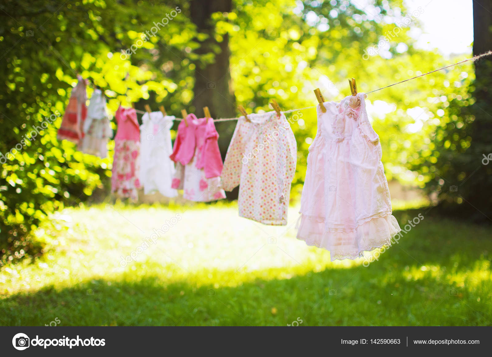 Little girl's clothes hanging on rope in the sunny Stock Photo by ©o_yaremchuk