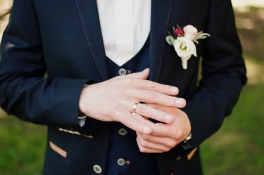 Mavi takım elbiseli bir adam alyansını çıkarıyor. Yakından.