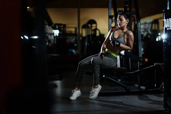 Mujer atlética en el gimnasio descansando sentado antes del ejercicio —  Fotos de Stock