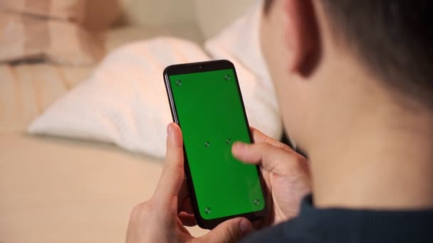 Pria memegang smartphone di tangan layar hijau hijau layar hijau, tangan manusia memegang ponsel pintar dengan kroma — Stok Video