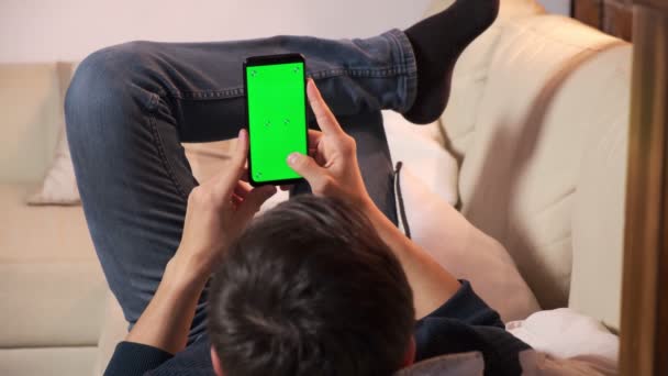 緑色の画面の手にスマートフォンを持った男クロマと携帯電話を持った男の手 — ストック動画