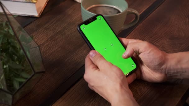 Muž drží smartphone v rukou zelené obrazovky zelené obrazovky, ruka muže drží mobilní chytrý telefon s chroma — Stock video