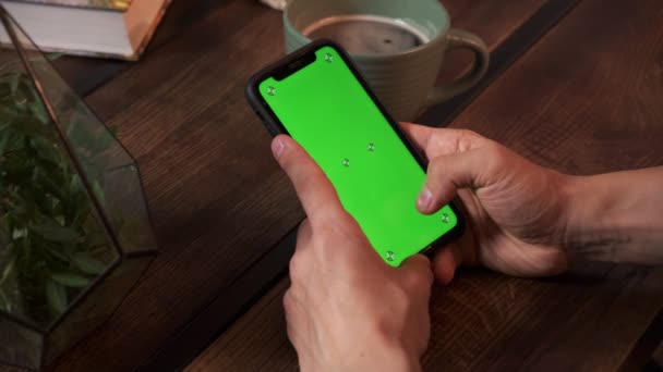 Hombre sosteniendo un teléfono inteligente en las manos de una pantalla verde pantalla verde, mano del hombre sosteniendo el teléfono inteligente móvil con croma — Vídeo de stock