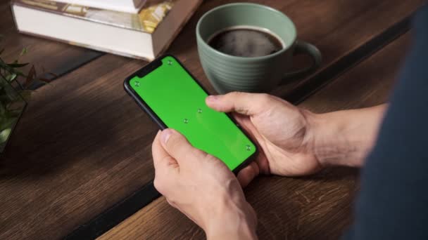 Hombre sosteniendo un teléfono inteligente en las manos de una pantalla verde pantalla verde, mano del hombre sosteniendo el teléfono inteligente móvil con croma — Vídeo de stock