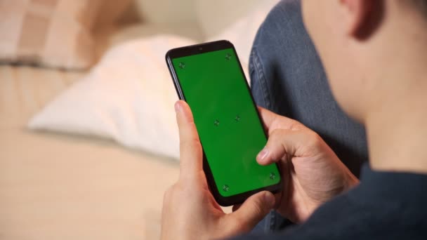 Homem segurando um smartphone nas mãos de uma tela verde tela verde, mão de homem segurando telefone inteligente móvel com chroma — Vídeo de Stock