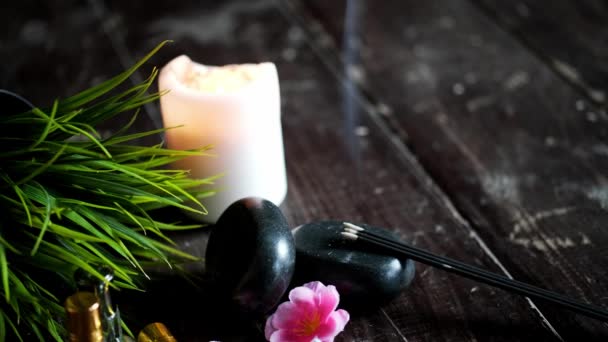 Kamienie do masażu i zbliżenie świec na drewnianym ciemnym tle — Wideo stockowe