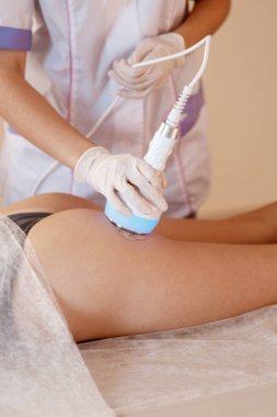 Donanım kozmetolojisi. Vücut bakımı. Spa tedavisi. Ultrason boşluğu, vücut hatları, tedavi. Kadın güzellik salonunda anti-selülit ve anti-yağ tedavisi görüyor..