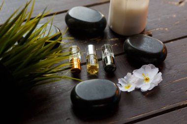 Masaj taşları ve mum, ahşap bir arka planda yakın plan. 