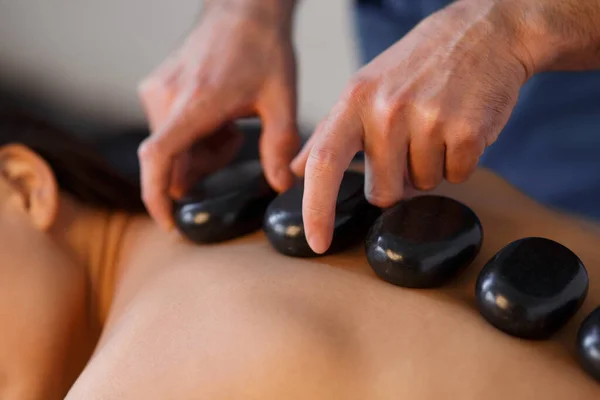 Junge Asiatin genießt die therapeutische Wirkung einer traditionellen Hot-Stone-Massage im luxuriösen Spa- und Wellnesszentrum — Stockfoto