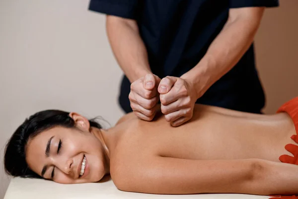 Genç bir kadın masaj prosedürü yaptırıyor. Masör Sırt Masajı Yapıyor. — Stok fotoğraf