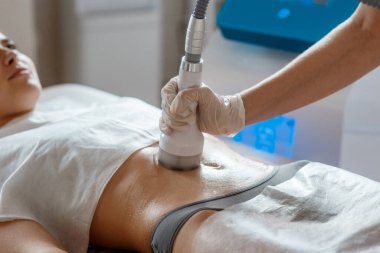 Donanım kozmetolojisi. Vücut bakımı. Spa tedavisi. Ultrason boşluğu, vücut hatları, tedavi. Kadın karşı çıkıyor.