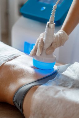 Donanım kozmetolojisi. Vücut bakımı. Spa tedavisi. Ultrason boşluğu, vücut hatları, tedavi. Kadın karşı çıkıyor.