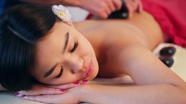 Чоловічий масаж робить масаж спини для дівчини азіатського вигляду. Розслаблення і масаж тоніків. — стокове відео