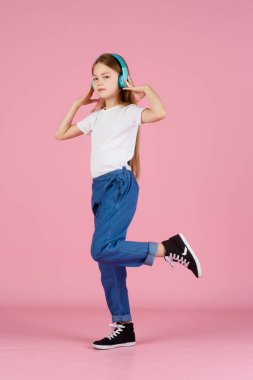Dans ve şarkı. Gençler müzik dinler. İlgiye dayalı müzik önerildi. Mobil cihaz için bedava müzik uygulamaları. Enerjik çalma listesi. Güzel liseli kız beyaz kulaklıklar müzik dinliyor..