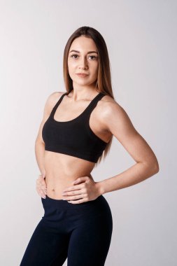 Atletik kadın tıp topuyla egzersiz yapıyor. Siyah arka planda sportif Latin kadın spor kıyafetinin fotoğrafı. Kuvvet ve motivasyon.