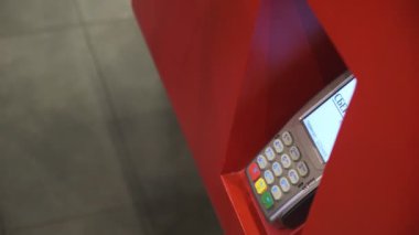 Genç bir adam telefon satın alır. Ulaşılmaz bir şekilde, self servis makinesinden. Erkekler telefonla öder. Kapat. 4k Video 