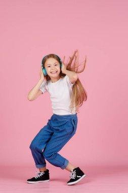 Dans ve şarkı. Gençler müzik dinler. İlgiye dayalı müzik önerildi. Mobil cihaz için bedava müzik uygulamaları. Enerjik çalma listesi. Güzel liseli kız beyaz kulaklıklar müzik dinliyor..