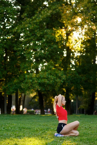 Young girl doing yoga in nature in the park .