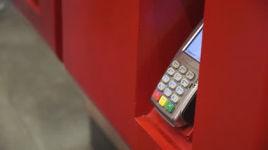 Genç bir adam telefon satın alır. Ulaşılmaz bir şekilde, self servis makinesinden. Erkekler telefonla öder. Kapat. 4k Video 