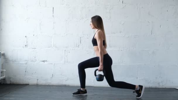 Spor giymiş güzel bir kadın yoga minderinde tahta egzersizi yapıyor.. — Stok video