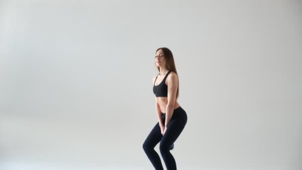 Atletische vrouw doet kettlebell schommels. Foto van latijnse vrouw met goede lichaamsbouw in modieuze sportkleding geïsoleerd op — Stockvideo