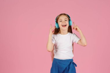 Dans ve şarkı. Gençler müzik dinler. İlgiye dayalı müzik önerildi. Mobil cihaz için bedava müzik uygulamaları. Enerjik çalma listesi. Güzel liseli kız beyaz kulaklıklar müzik dinliyor..