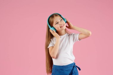 Dans ve şarkı. Gençler müzik dinler. İlgiye dayalı müzik önerildi. Mobil cihaz için bedava müzik uygulamaları. Enerjik çalma listesi. Güzel liseli kız beyaz kulaklıklar müzik dinliyor..