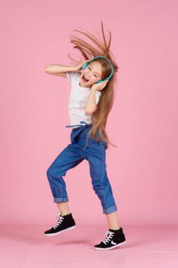 Dans ve şarkı. Gençler müzik dinler. İlgiye dayalı müzik önerildi. Mobil cihaz için bedava müzik uygulamaları. Enerjik çalma listesi. Güzel liseli kız beyaz kulaklıklar müzik dinliyor..