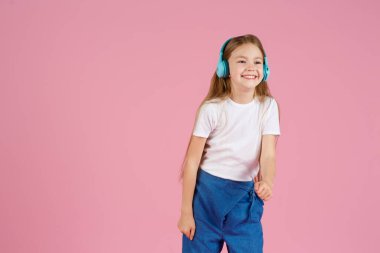 Dans ve şarkı. Gençler müzik dinler. İlgiye dayalı müzik önerildi. Mobil cihaz için bedava müzik uygulamaları. Enerjik çalma listesi. Güzel liseli kız beyaz kulaklıklar müzik dinliyor..