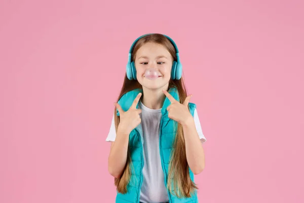 Ein Kleines Mädchen Mit Kopfhörern Explodiert Rosa Kaugummi Auf Rosa — Stockfoto