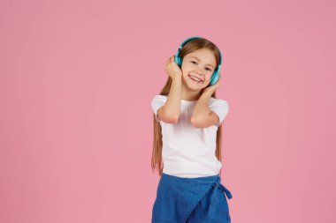 Dans ve şarkı. Gençler müzik dinler. İlgiye dayalı müzik önerildi. Mobil cihaz için bedava müzik uygulamaları. Enerjik çalma listesi. Güzel liseli kız beyaz kulaklıklar müzik dinliyor..