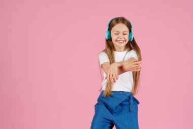 Dans ve şarkı. Gençler müzik dinler. İlgiye dayalı müzik önerildi. Mobil cihaz için bedava müzik uygulamaları. Enerjik çalma listesi. Güzel liseli kız beyaz kulaklıklar müzik dinliyor..