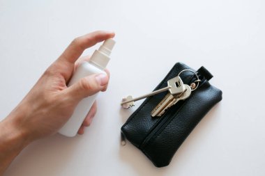 Corona virüsü veya covid-19 gibi bakteri ve virüslerden dezenfekte etmek için anahtarlara alkol spreyi uygulanıyor.