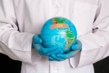 Mavi arka planda izole edilmiş tıbbi elbise, steril yüz maskesi eldivenli erkek doktor görüntüsü. Salgın Coronavirüs 2020-ncov sarars covid-19 grip virüsü konsepti. Dünya 'yı tut