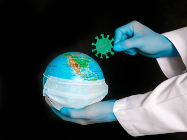 Konsept, gezegeni koronavirüsten korumak. Antiseptiği küreye dök. Covid-19 ve dünya doktorun elinde.