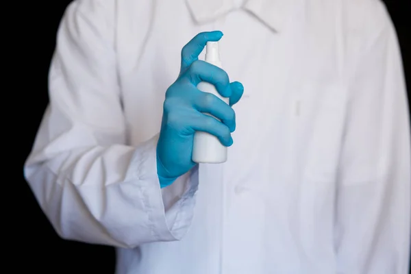Close up view of female physician hands showing a personal antiseptic or sanitizer. Covid-19 protection measures. Doctor in white medical gown at clean white background.