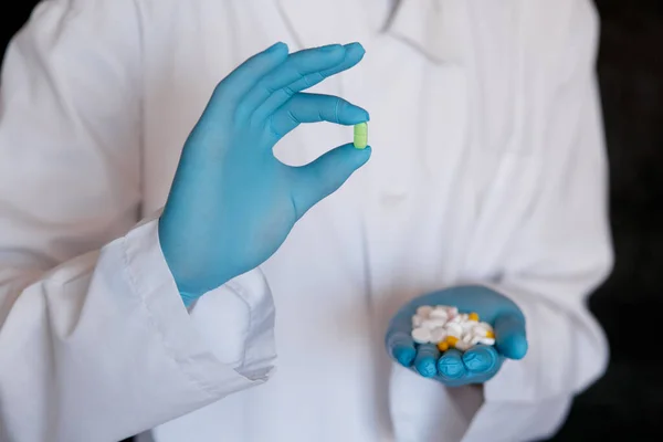 Wiele Małych Białych Pigułek Rękach Lekarza Noszącego Medyczne Niebieskie Jednorazowe — Zdjęcie stockowe