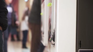 Genç bir adam telefon satın alır. Ulaşılmaz bir şekilde, self servis makinesinden. Erkekler telefonla öder. Kapat. 4k Video 