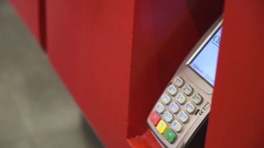 Genç bir adam telefon satın alır. Ulaşılmaz bir şekilde, self servis makinesinden. Erkekler telefonla öder. Kapat. 4k Video 
