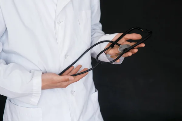 Mężczyzna Lekarz Czarny Tło Stetoskop Jego Ręce Zbliżenie — Zdjęcie stockowe
