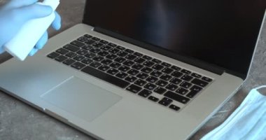 Genç Hintli iş adamı, ofis masasında oturan dizüstü bilgisayarda çalışırken tıbbi maske eldivenleri takıyor.