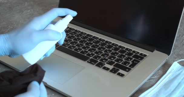 Ufficio sanificazione durante coronavirus pandemia concetto focolaio. Uomo lavoratore indossa protettivo viso maschera pulizia laptop — Video Stock
