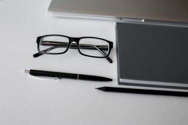 Masada bir sürü tablet, laptop, akıllı telefon ve kahve fincanı defteri var. Kopyalama alanı olan üst görünüm, düz yatay.