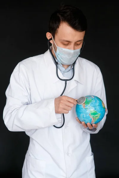 A doctor with a stethoscope auscultates the respiration of the lungs of the planet Earth - pneumonia and coronavirus in the USA - medical diagnostic