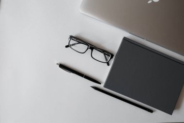 Masada bir sürü tablet, laptop, akıllı telefon ve kahve fincanı defteri var. Kopyalama alanı olan üst görünüm, düz yatay.