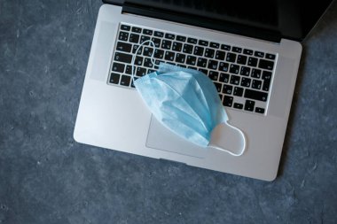 Coronavirüs salgını sırasında evde robot var. Yüz grisi için covid-19 yakın çekim maskesine karşı korunaklı dizüstü bilgisayar