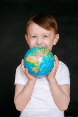 Gri arka planda gözlerinde korku olan maske takan bir çocuğun yüzü. Coronavirus ve Hava kirliliği kavramı