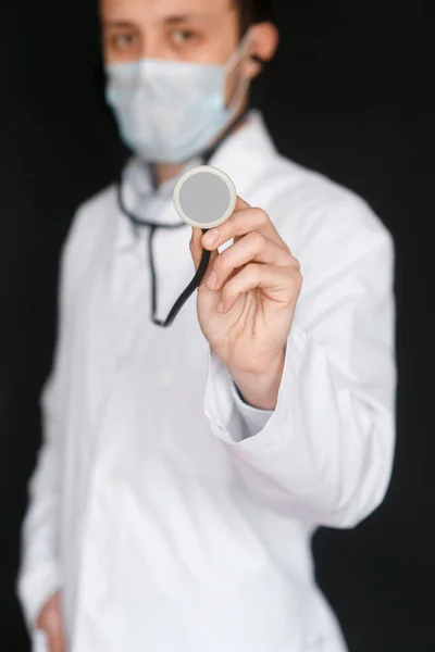 Dottore Maschio Uno Sfondo Nero Con Uno Stetoscopio Nelle Mani — Foto Stock